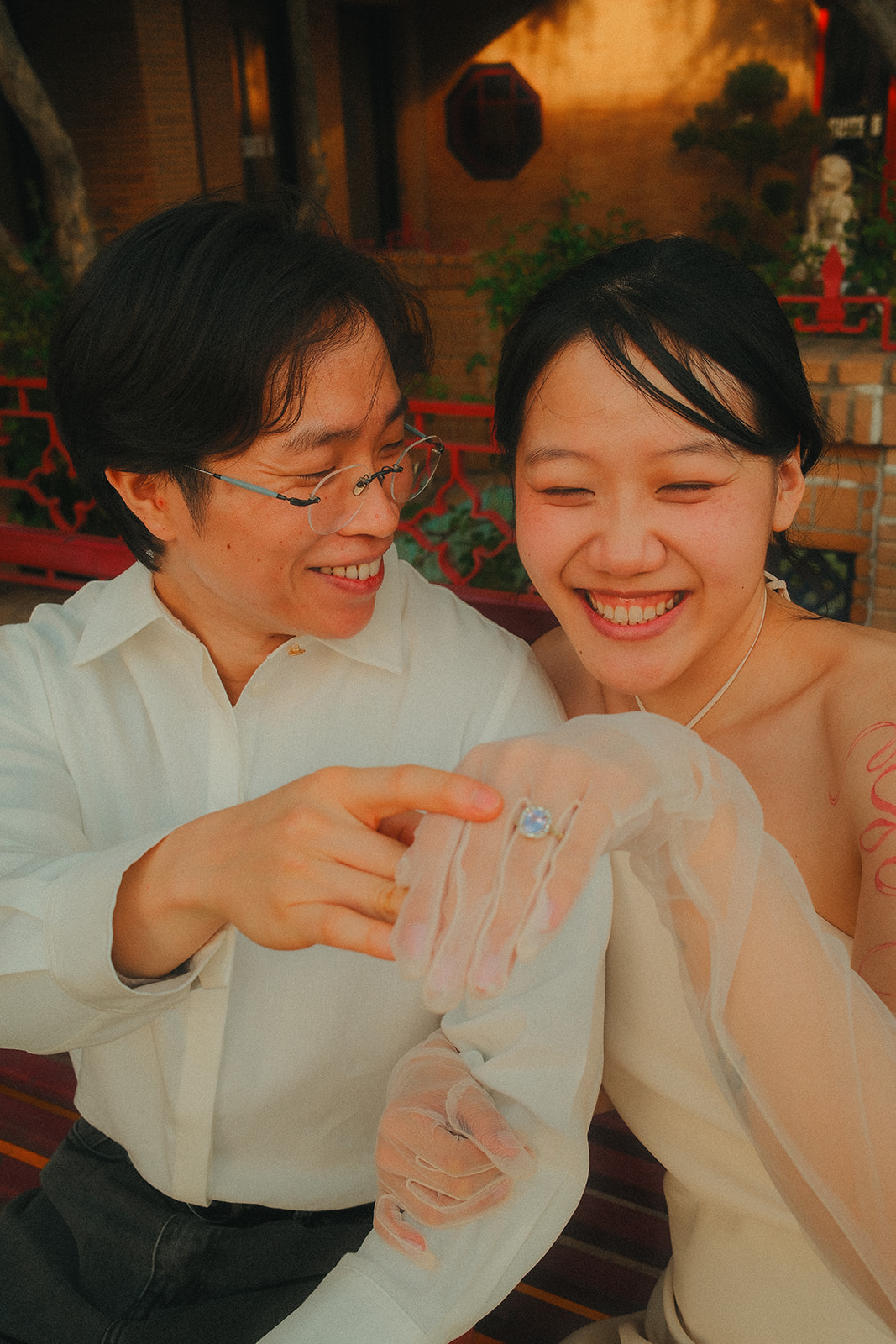 Looking at the engagement ring and laughing